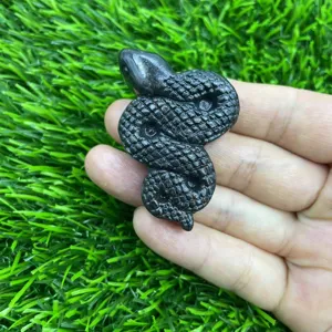 Gros plan détaillé d'une figurine de serpent en pierre noire sculptée à la main.