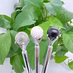 Detail view of crystal sphere ball pens with shiny silver metal barrels and stone tops.