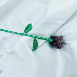 Dettaglio di rosa in cristal con testa di fiore scolpita e stelo in metallo verde.