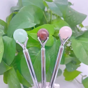 Closeup of crystal sphere ball pens with natural stone beads, elegant metal body for office.