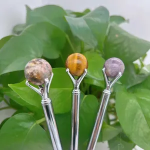 Detail view of crystal sphere ball pens with natural stone beads on metal shafts.