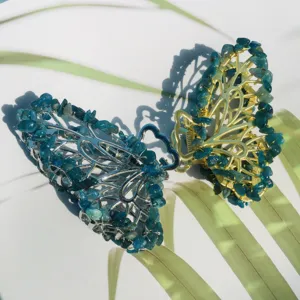 Vue détaillée de la pince à cheveux papillon avec cristaux bleus et monture en métal.
