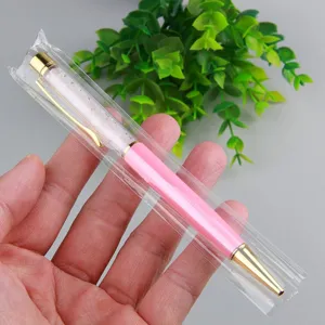 Detailed close-up of a pink crystal sphere ball pen with gold trim in clear plastic sleeve.