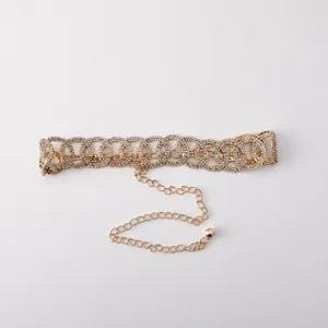 Vista dettagliata della scintillante cintura a catena con strass, elegante design dorato.