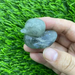Gros plan détaillé d'une figurine de canard en cristal sculptée à main avec texture minérale.