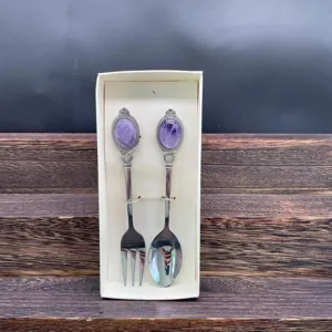 Dettaglio del set cucchiaio e forchetta in acciaio inox con manico in ametista scolpita.