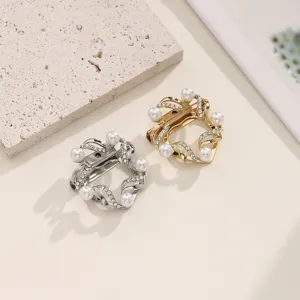 Detailopname van glanzende parel en strass metalen sjaalgesp en broche in goud en zilver.