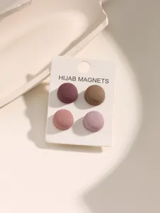 Gedetailleerde close-up van vier matte kleurrijke ronde hijab magneten op displaykaart.