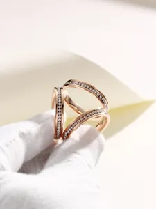 Vue détaillée d'une élégante boucle de foulard en or rose ornée de strass étincelants.