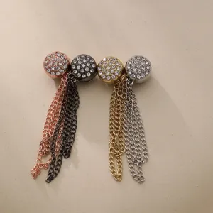 Close-up of sparkling rhinestone magnetic buttons with hanging chains in various colors.