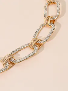 Close-up detail of a glamorous gold-tone rhinestone chunky chain waist accessory.