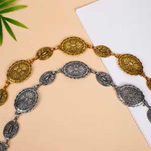 Close-up detail of retro bohemian metallic waist chain, intricate geometric coin links.