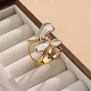 Detail view of the gold-tone enamel flower scarf buckle with sparkling rhinestones for versatile styling.