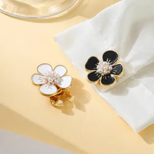 Gros plan de boutons de manchette floraux élégants avec perles en alliage de zinc pour chemises.