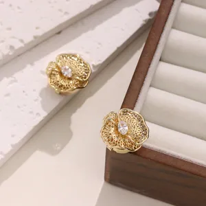 Close-up detail of golden filigree flower button cover with central sparkling cubic zirconia stone.