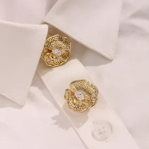 Close-up detail of golden filigree flower button covers with sparkling oval cubic zirconia.