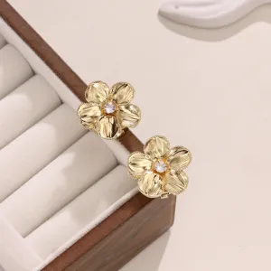 Dettaglio di gemelli a fiore dorato con zircone cubico brillante per camicia da uomo.