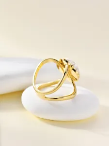 Close-up detail of gold-toned metal scarf ring buckle with decorative pearl accent.
