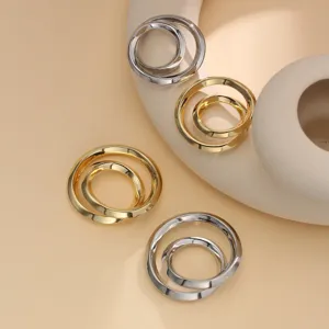 Metal scarf buckle detail view showing gold and silver interlocking rings for clothing hems.