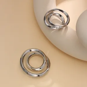Silver metal interlocking scarf ring detail, sleek minimalist clothing corner clip.