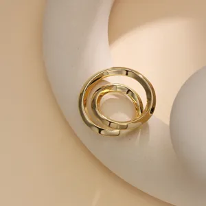 Close-up detail of a minimalist gold metal scarf buckle and elegant clothes knotting clip.