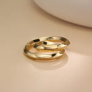 Detailed view of a sleek gold-tone metal twist ring scarf buckle, elegant accessory closeup.