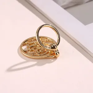 Gold hollow metal silk scarf buckle, elegant round design shawl ring clip accessory.