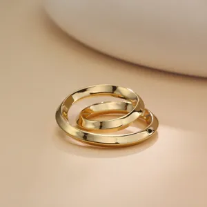 Close-up detail shot of shiny gold metal nested rings, smooth polished surface, elegant style.