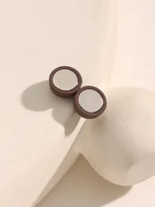 Close-up detail van de ronde magnetische knop met een bruine rand en metalen middenafwerking.