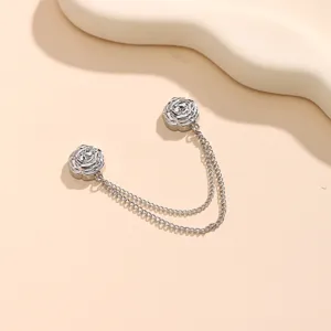 Silver camellia flower magnetic buckle with double chains for clothing decoration detail.