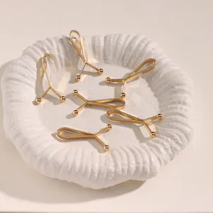 Vue détaillée de pinces multifonctions en métal doré pour vêtements et foulards élégants.