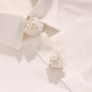 Detailed closeup view of elegant white camellia flower button covers for shirts.