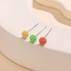 Nahaufnahme bunter Wachsperlen-Kopfnadeln im Detail, die exquisite Texturen und Farben zeigen.