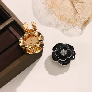 Vista dettagliata dell'accessorio di copertura per bottoni di camicia camelia nero e oro.