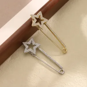 Detailed close-up of shiny crystal star safety pins in gold and silver, perfect shawl and scarf brooches.