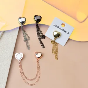 Detail shot of multi-functional heart-shaped magnetic hijab pins with delicate chain drapes.