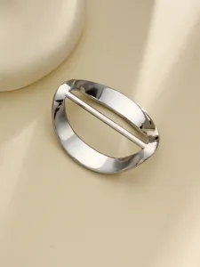 Detail shot of a sleek silver metal shirt hem clip ring, ideal for styling t-shirts and silk scarves.