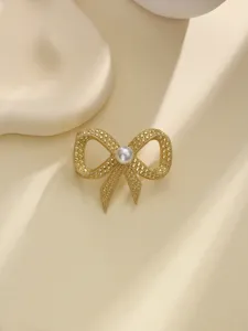 Elegante clip per sciarpa a fiocco dorato con perla, ideale per valorizzare scialli e abiti.