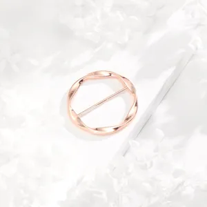 Rose gold twisted circular scarf ring buckle, minimalist fashion accessory for shawl clothing corner.