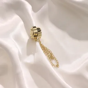 Close-up detail of the gold magnetic clothing buckle with a delicate chain design.