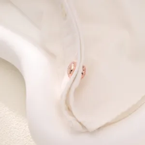 Close-up detail of a round rose gold magnetic scarf buckle, perfect for elegant apparel styling.