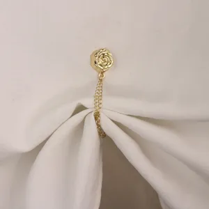Gold rose magnetic clothing clip detail shot, elegant t-shirt corner buckle and scarf accessory.