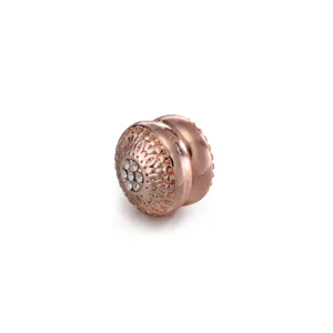 Detail shot of rose gold magnetic scarf buckle with intricate floral pattern and central rhinestones.