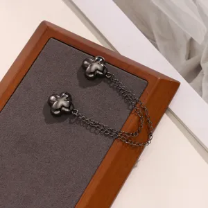 Detail shot of black magnetic clover clothing waist buckle with double metal chains for styling.