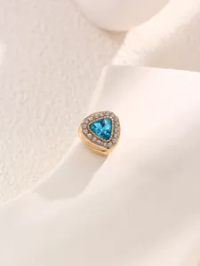Close-up detail of a triangular magnetic scarf clip featuring blue and clear rhinestones.