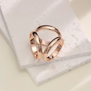 Gros plan détaillé d'une boucle d'écharpe triple anneau en or rose brillant, texture.