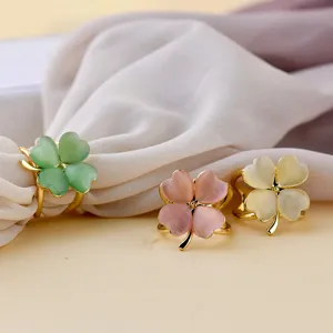 Close-up detail of lovely four-leaf clover scarf buckles featuring glossy cat eye stone.