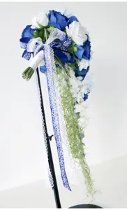 Atemberaubender kaskadierender Brautstrauß mit blauen weißen Rosen und eleganten Bändern.