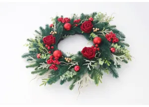 Detailed view of the artificial Christmas wreath with pine needles, red roses, and festive berries.