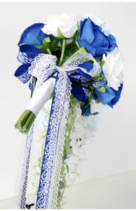 Nahaufnahme des kaskadenförmigen blauen weißen künstlichen Rosenbrautstraußes mit Spitzenband.